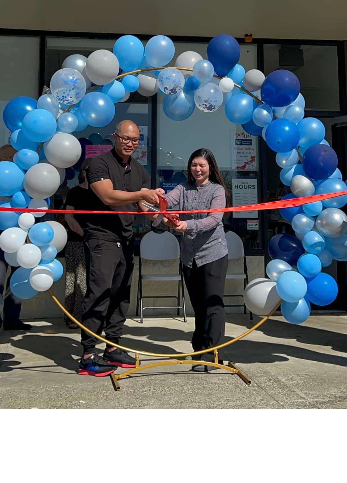 Joel and Kristine Cardenas cutting the ribbon at South Kitsap Pharmacy's grand opening